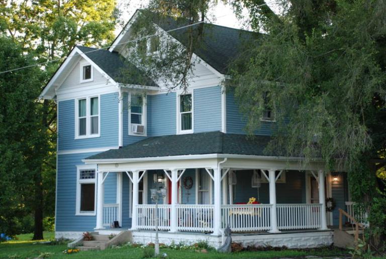A house with blue vinyl siding and white trim