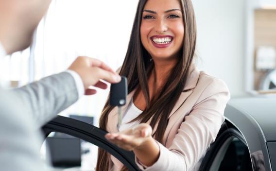 smiling car salesman handing over your new car keys happy girl the picture