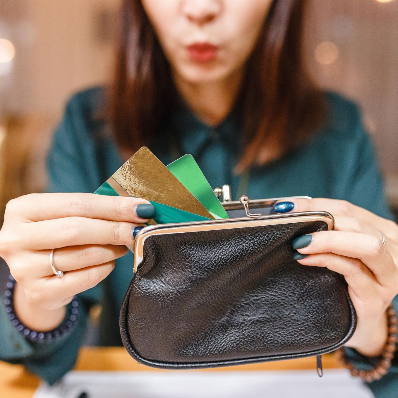 Surprised woman taking out from wallet two credit cards