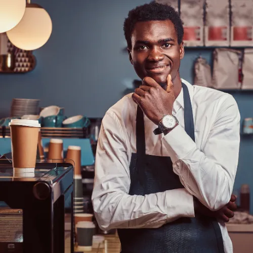 Person with an apron on in coffee shop