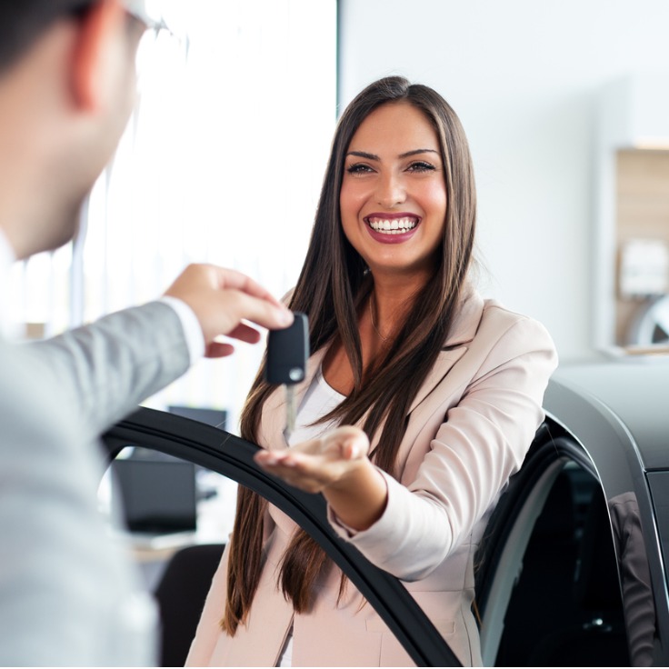 smiling car salesman handing over your new car keys happy girl the picture