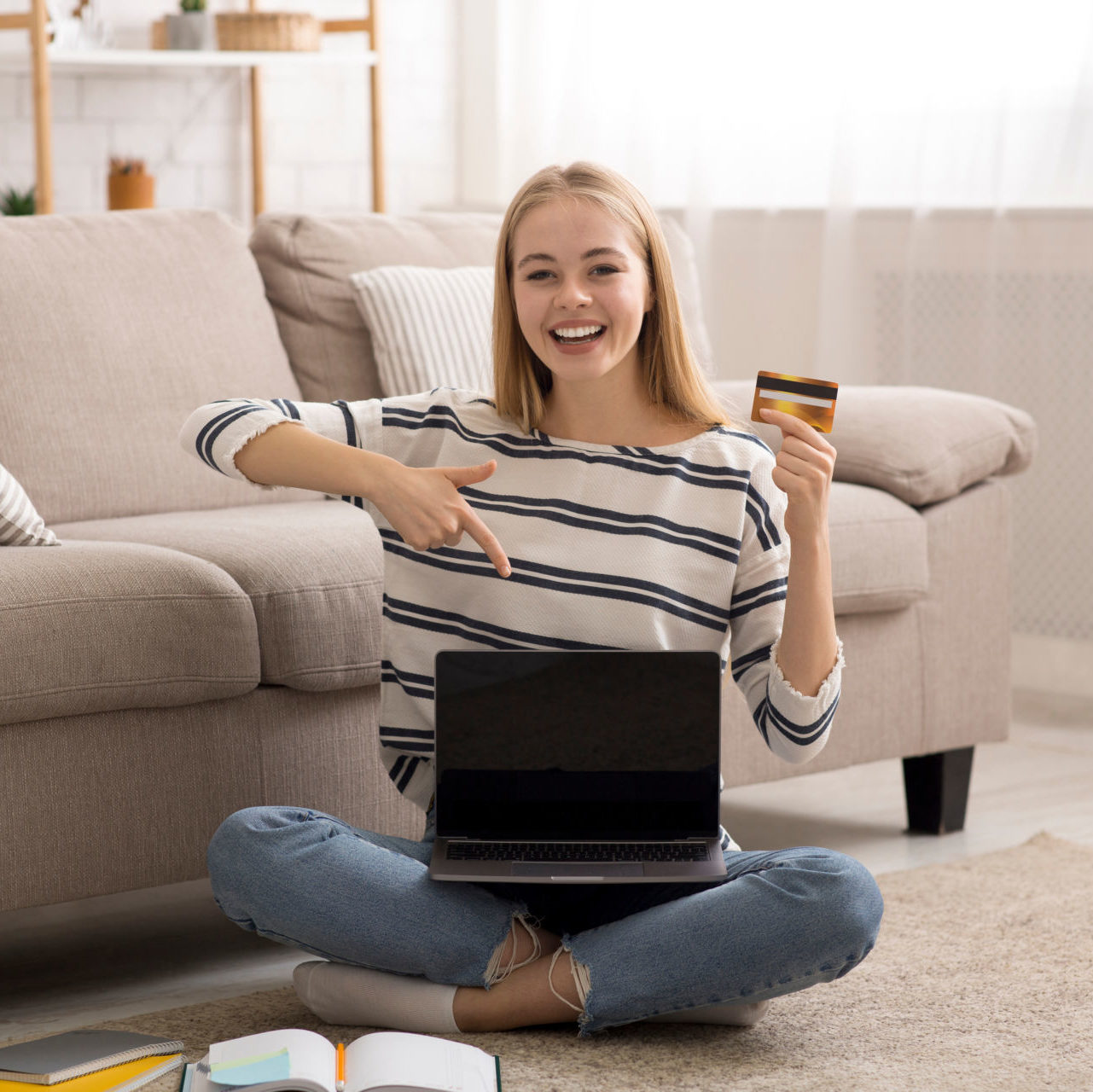 a young woman smiles, excited about learning how to get a student credit card for the first time