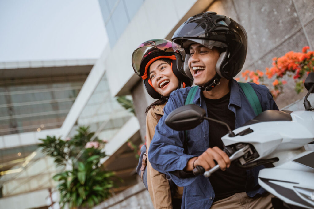 Using their credit union vehicle loan, a happy couple rides off in their new motorcycle.