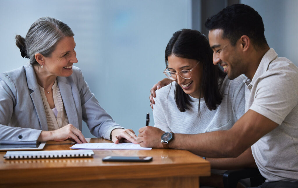 A couple talks with a credit union representative about refinancing their auto loan.